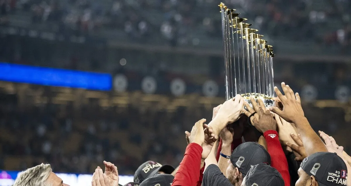 The 2018 World Series trophy, lifted by a crowd of Red Sox hands at Dodger Stadium
